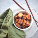 You can made tofu in your air fryer! This recipe for sesame ginger tofu uses a quick marinade with sesame oil, and soy sauce as its base to create a perfect crispy tofu to add to noodle bowls, salads or wraps.