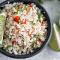 This mexican cauliflower rice uses simple ingredients and is cooked in a skillet for an easy side dish. Cauliflower rice is a great low carb, keto or whole30 alternative to white or brown rice. #whole30 #paleo #keto #lowcarb #sidedish #rice