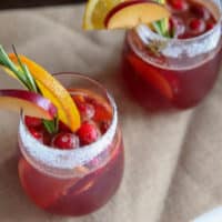 This easy Christmas punch is made with fresh ingredients like ginger ale, cranberry juice, plums and orange with a touch of cinnamon. Makes a great cocktail or mocktail for december holiday parties.