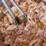 shredded pulled pork with tongs