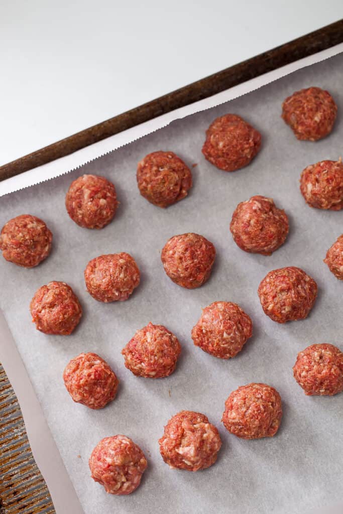 raw meatballs on a sheet pan