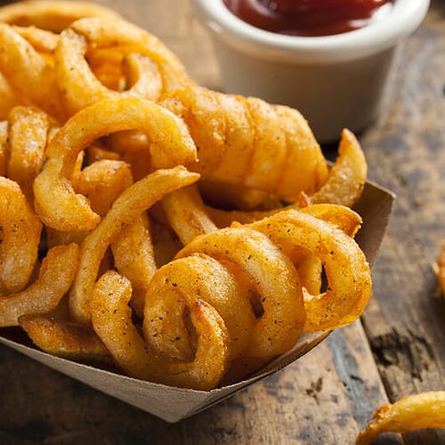 curly fries in a basket with ketchup