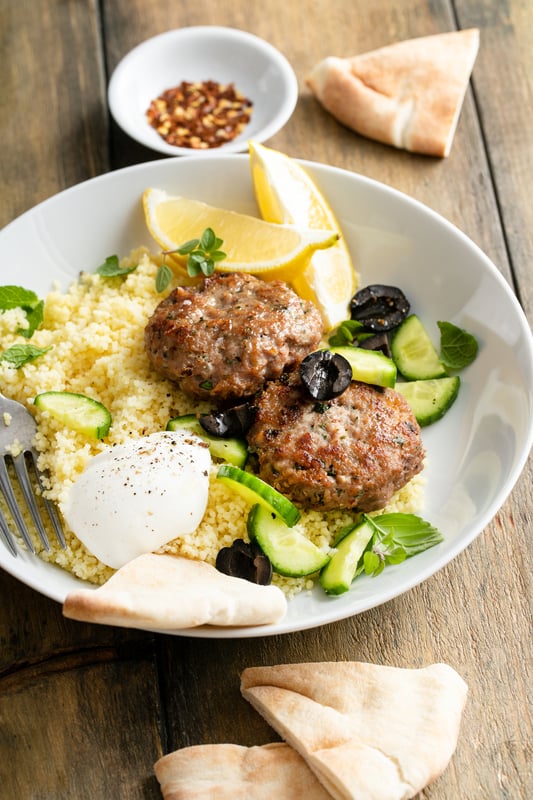 lamb burgers on a plate with vegetables