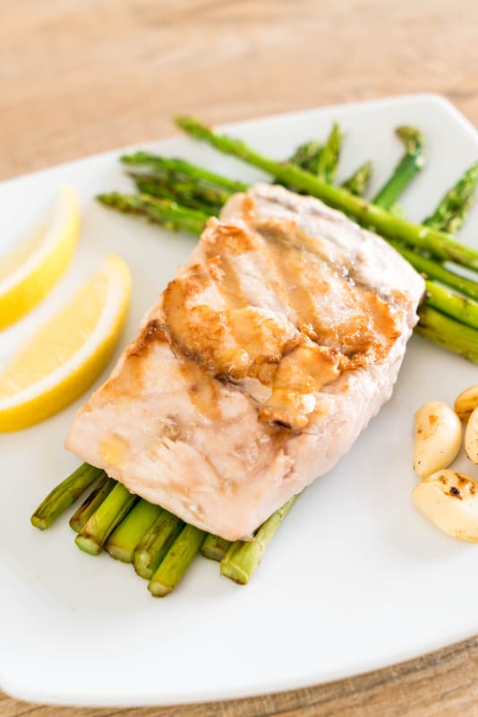 cooked snapper on a plate with asparagus