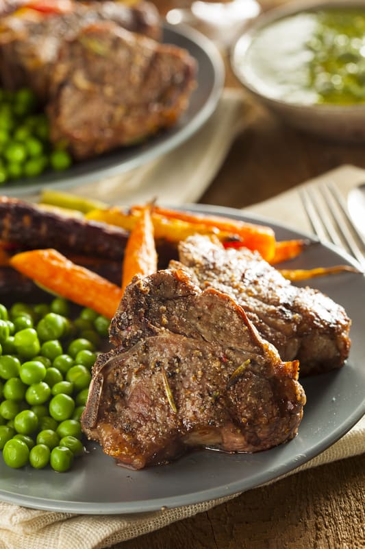 lamb chops reverse seared on a plate with vegetables