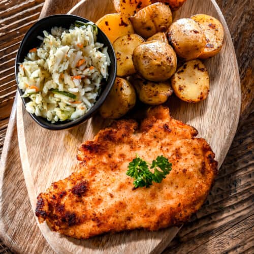 chicken cutlet on a plate with potatoes and rice