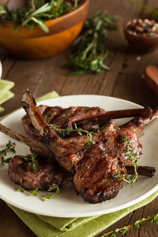 lamb chops on a plate with herbs