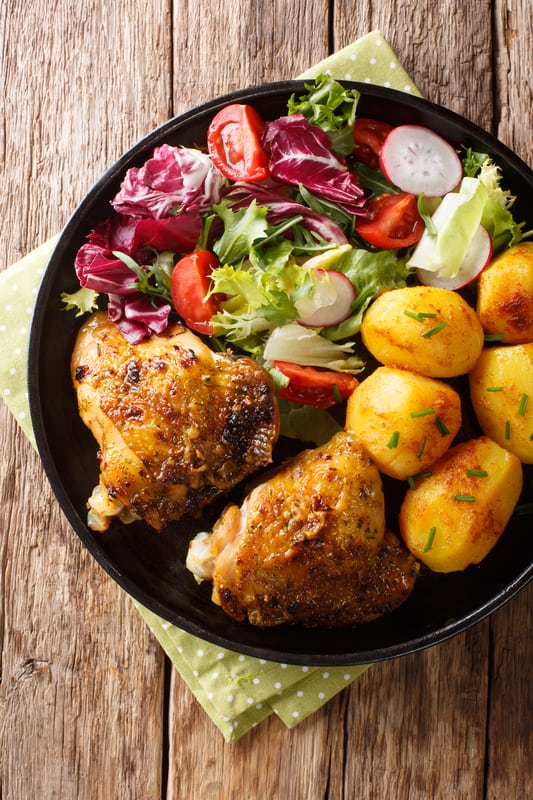 chicken thighs on a plate with vegetables
