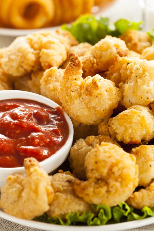 popcorn shrimp with cocktail sauce on a plate